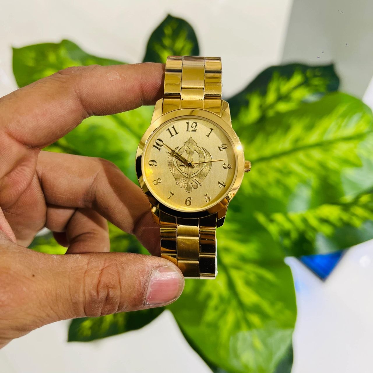 Gold-toned analog watch engraved Khanda symbol on the dial