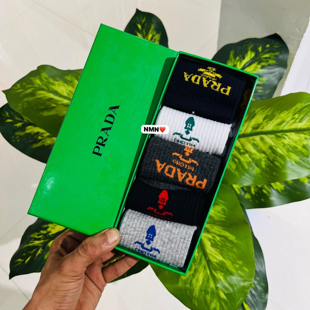 Pack of five Prada logo-embroidered crew socks presented in a vibrant green branded gift box.